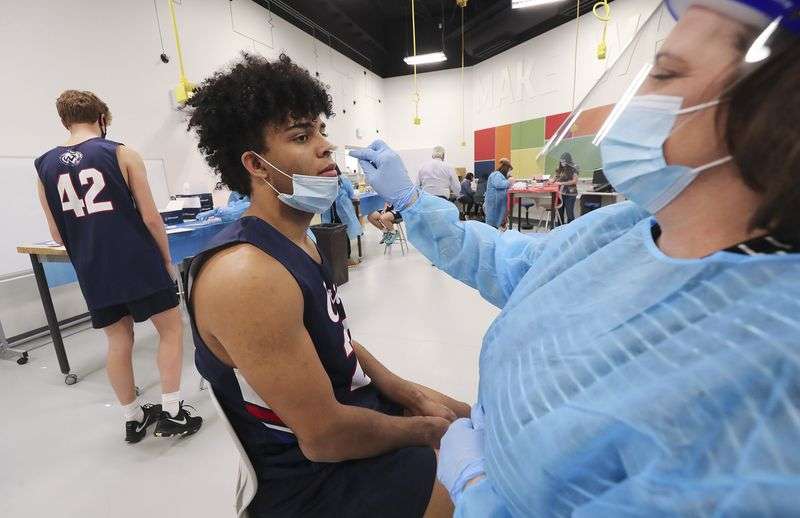 Woods Cross High School basketball player Kiegan Phung
gets a COVID-19 test from registered nurse Shanna Robbins at the
school in Woods Cross on Wednesday, Dec. 2, 2020. A state public
health order requires that high schools verify that each
participant in athletic and extracurricular activities receive a
COVID-19 test before taking part in the activity.