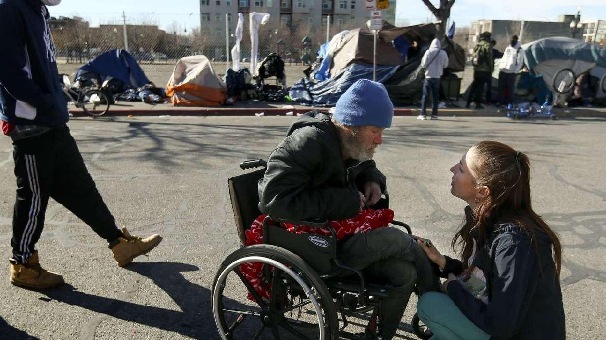 Kseniya Kniazeva, executive director of Nomad Alliance,
right, speaks to Jason Gove about obtaining a new wheelchair for
him on Rio Grande Street in Salt Lake City on Sunday, Feb. 7, 2021.
Utah’s 2021 legislative session marked milestones in investments in
affordable housing and sweeping changes to the homeless governance
system, all meant to enact measurable improvements in two of the
Beehive State’s biggest issues.