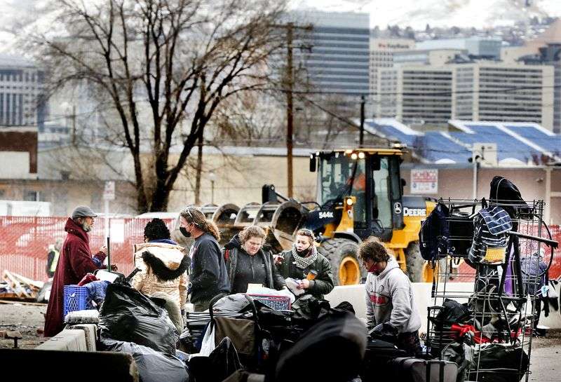 Volunteers and homeless people sort through their
belongings as the Salt Lake County Health Department clears out
Camp Last Hope in Salt Lake City on Thursday, Feb. 4,
2021.