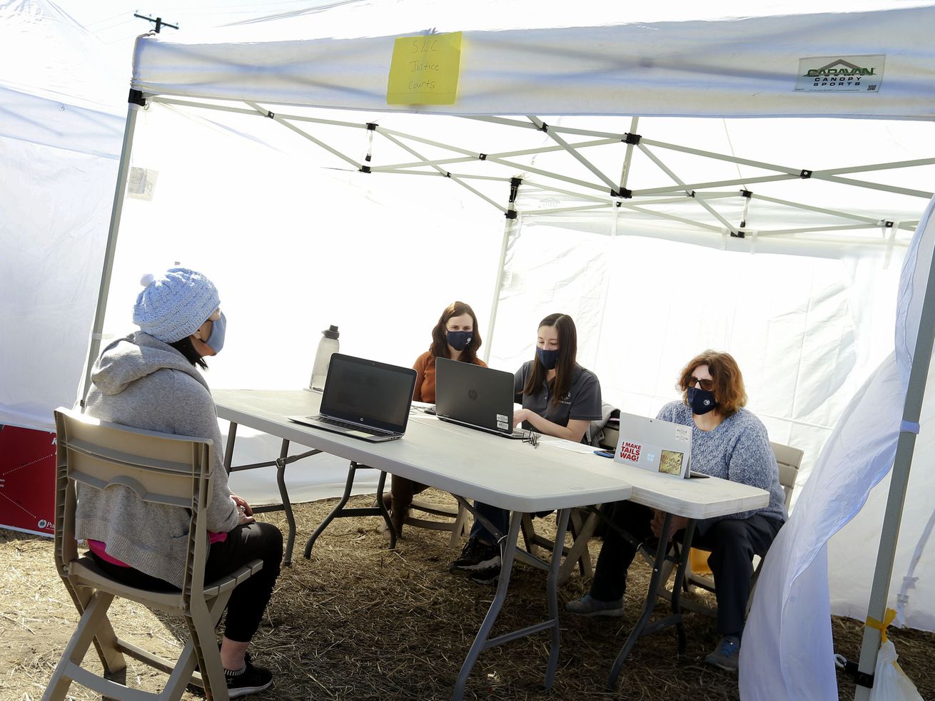 Marcella Lovell, left, attends Salt Lake County Justice
Court with judicial assistants Pauline Koranicki and Jennifer
Medrano and Judge Jeanne Robison at the Cornell Street tent city in
Salt Lake City on Wednesday, March 3, 2021. Lovell, 67, lives in
her camper at the tent city.
