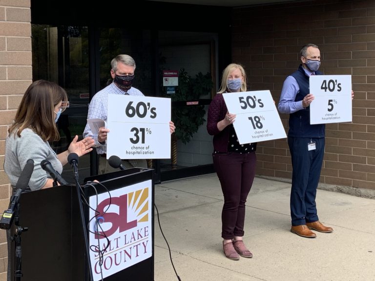 FILE: Salt Lake County Mayor Jenny Wilson, left, in front of the West Side Senior Center, while county workers held signs showing hospitalization rates among age groups.