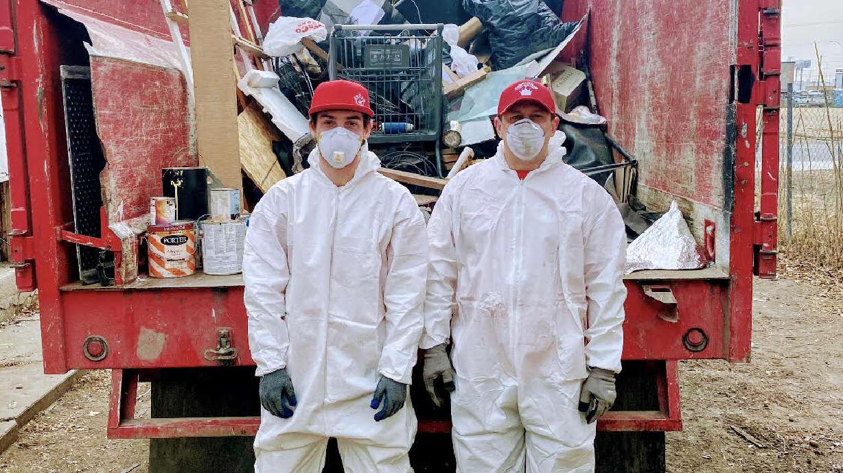 Luke Wren (right) stands with one of his employees after removing items from a local home.
