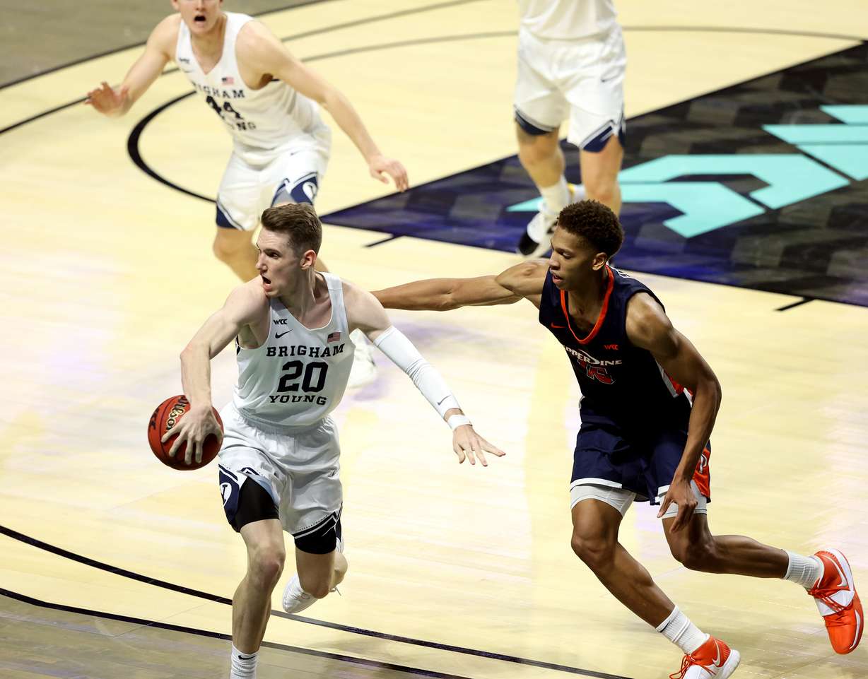 Brigham Young Cougars guard Spencer Johnson (20) flips the ball to teammate Brigham Young Cougars guard Connor Harding (44) after stealing the pass to Pepperdine Waves forward Kessler Edwards (15) as BYU and Pepperdine play in semifinal West Coast Conference tournament basketball action at the Orleans Arena in Las Vegas on Monday, March 8, 2021. BYU won 82-77 in overtime.