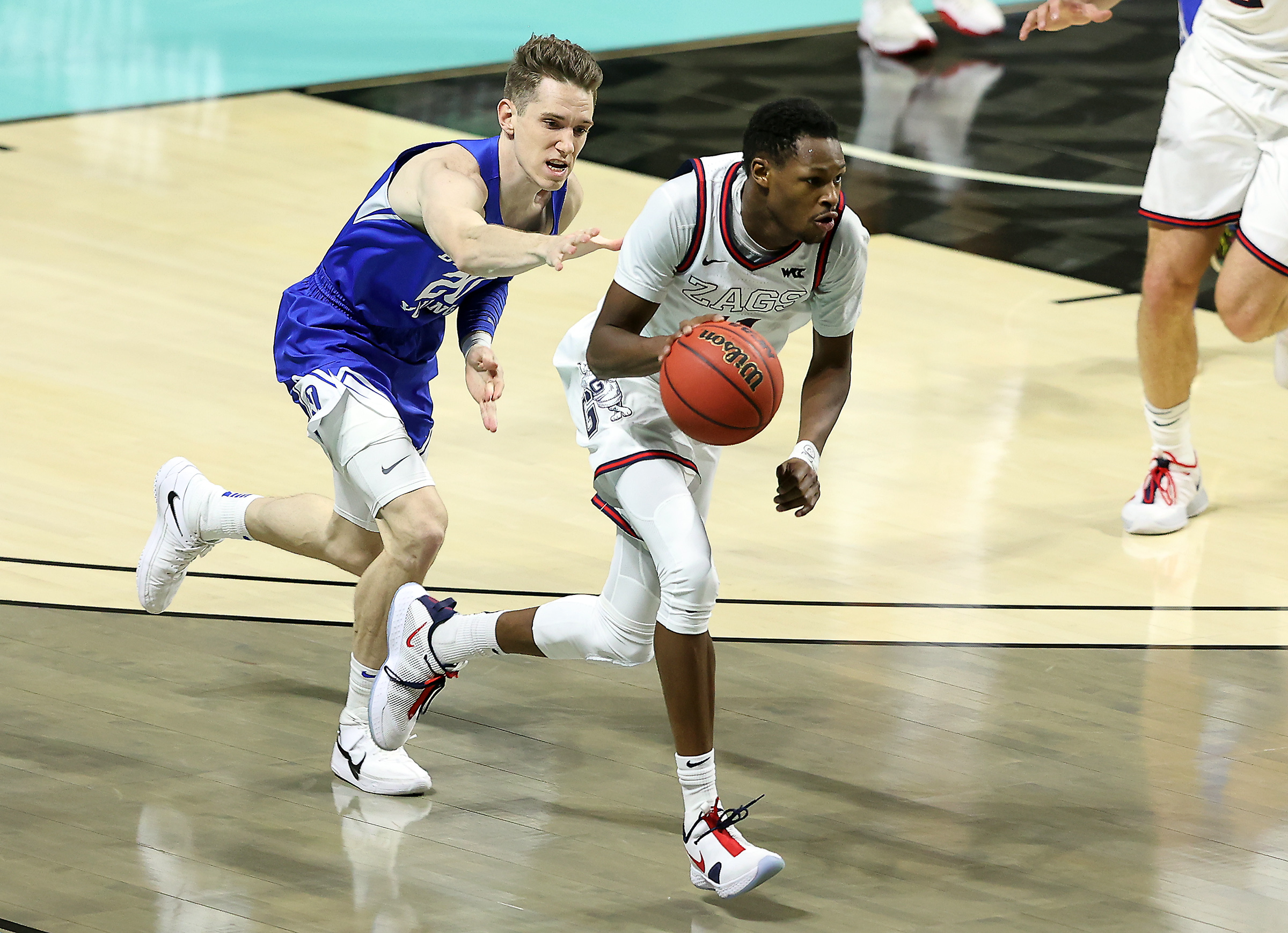 Brigham Young Cougars guard Spencer Johnson (20) reaches out to try to foul Gonzaga Bulldogs guard Joel Ayayi (11) as BYU and Gonzaga play in the finals of the West Coast Conference tournament at the Orleans Arena in Las Vegas on Tuesday, March 9, 2021. Gonzaga won 88-78.