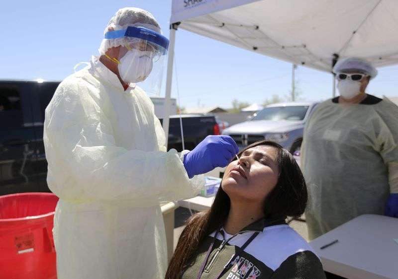 Andy Byrnes, a contracted EMT with the Utah Department
of Health, tests Audriana Nakai for COVID-19 outside of the
Montezuma Creek Community Health Center in Montezuma Creek, San
Juan County, on Friday, May 1, 2020.