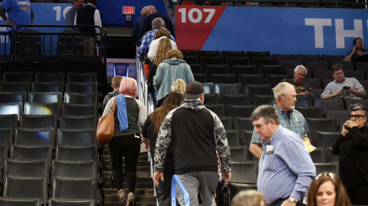 Basketball fans leave Chesapeake Energy Arena after it is announced that an NBA basketball game between Oklahoma City Thunder and Utah Jazz in Oklahoma City has been postponed, Wednesday, March 11, 2020.
