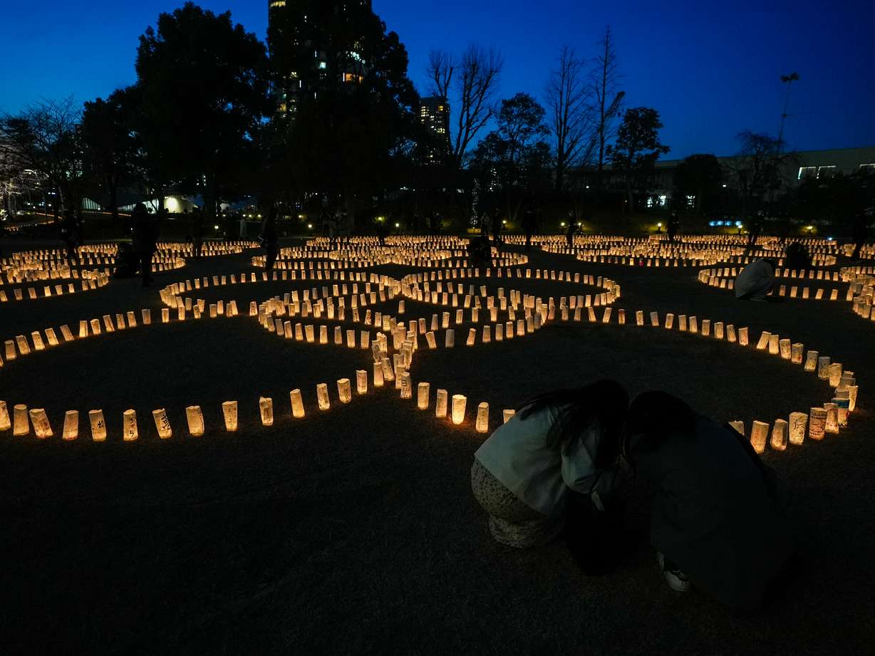 People look at paper lanterns lit for victims of the March 11, 2011 Japan earthquake and tsunami during the 10th anniversary since the disaster, Thursday, March 11, 2021.