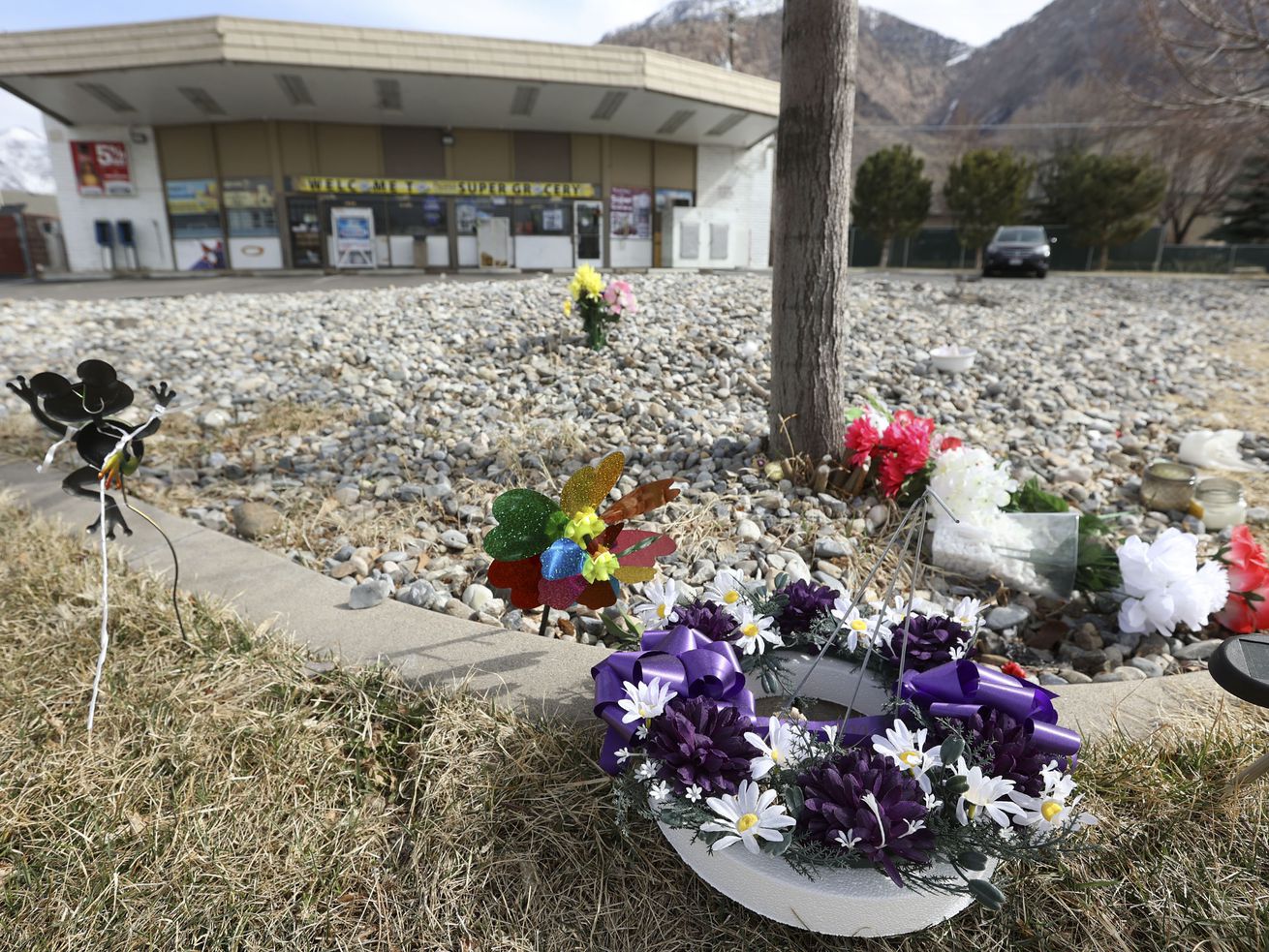 Flowers and pinwheels are pictured at a memorial outside of Super Grocery in Ogden on March 11, 2021. Satnam Singh, the store’s 65-year-old owner, was fatally shot while working behind the counter on Feb. 28. A now-16-year-old accused of killing him has tentatively accepted a plea deal.