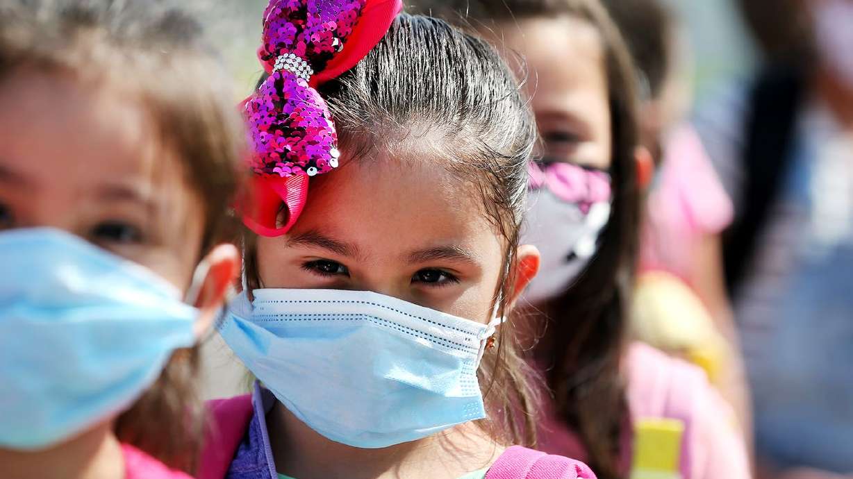 Students at Woodrow Wilson Elementary School in South
Salt Lake wear masks as they line up to get on their buses to go
home after their first day of school on Aug. 24, 2020. State School
Board members have voiced concerns about enforcing mask wearing in
schools after the statewide mask mandate is lifted for other
circumstances starting April 10.
