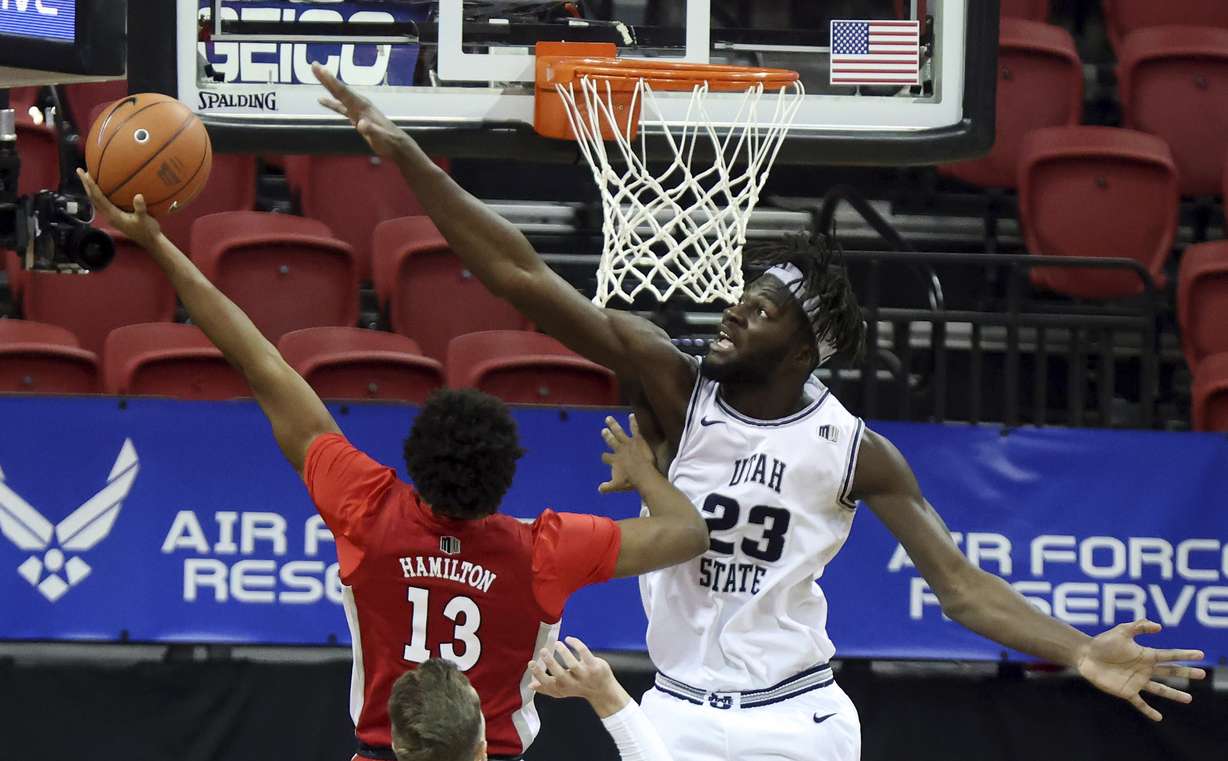 UNLV guard Bryce Hamilton (13) shoots as Utah State center Neemias Queta (23) defends during the first half of an NCAA college basketball game in the quarterfinals of the Mountain West Conference men's tournament Thursday, March 11, 2021, in Las Vegas.