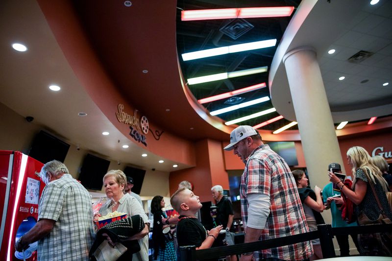 Brian Coombs, who booked a private screening for 30
friends and family members, talks to his son, Easton, as they get
concessions at the Megaplex Theatres at Legacy Crossing in
Centerville on May 29, 2020.
