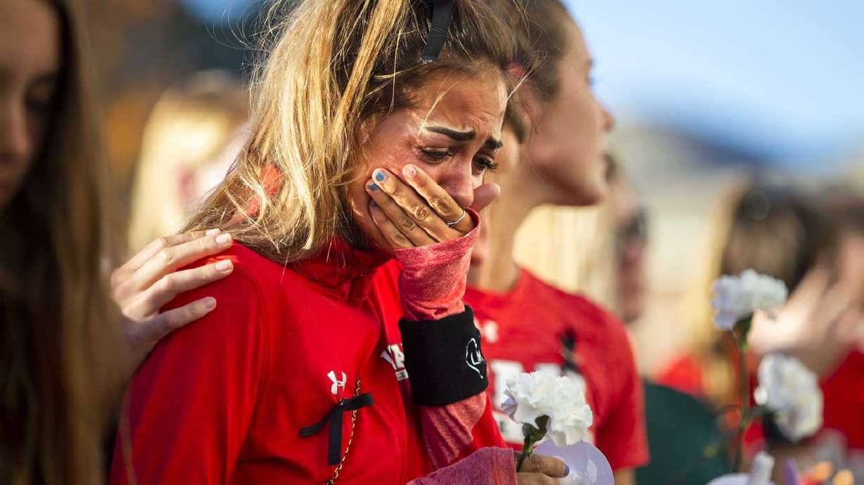 A member of the University of Utah track team reacts
during a vigil for Lauren McCluskey at the Park Building on the
University of Utah campus in Salt Lake City on Oct. 24, 2018. Gov.
Spencer Cox signed three bills dealing with policing in Utah,
including changes to the state’s revenge porn law that arose from
the investigation of the slain U. student when an officer shared
graphic images of her with others.