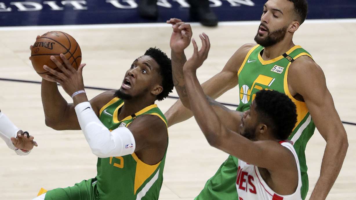 Utah Jazz guard Donovan Mitchell (45) shoots in front of Houston Rockets center Justin Patton (26) and Utah Jazz center Rudy Gobert (27) during an NBA game at the Vivint Smart Home Arena in Salt Lake City on Friday, March 12, 2021. The Jazz won 114-99.