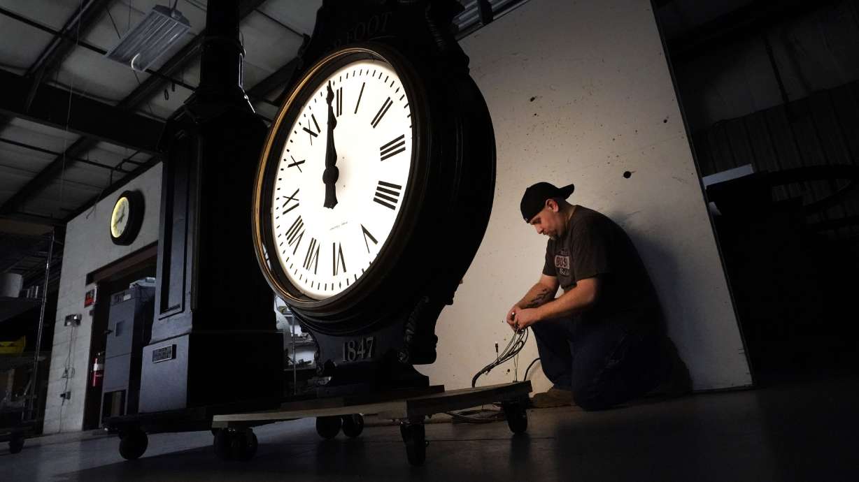 Electric Time technician Dan LaMoore lights up a two-dial Howard Post Clock, March 9, 2021, in Medfield, Mass. Clocks are set ahead an hour during daylight saving time.