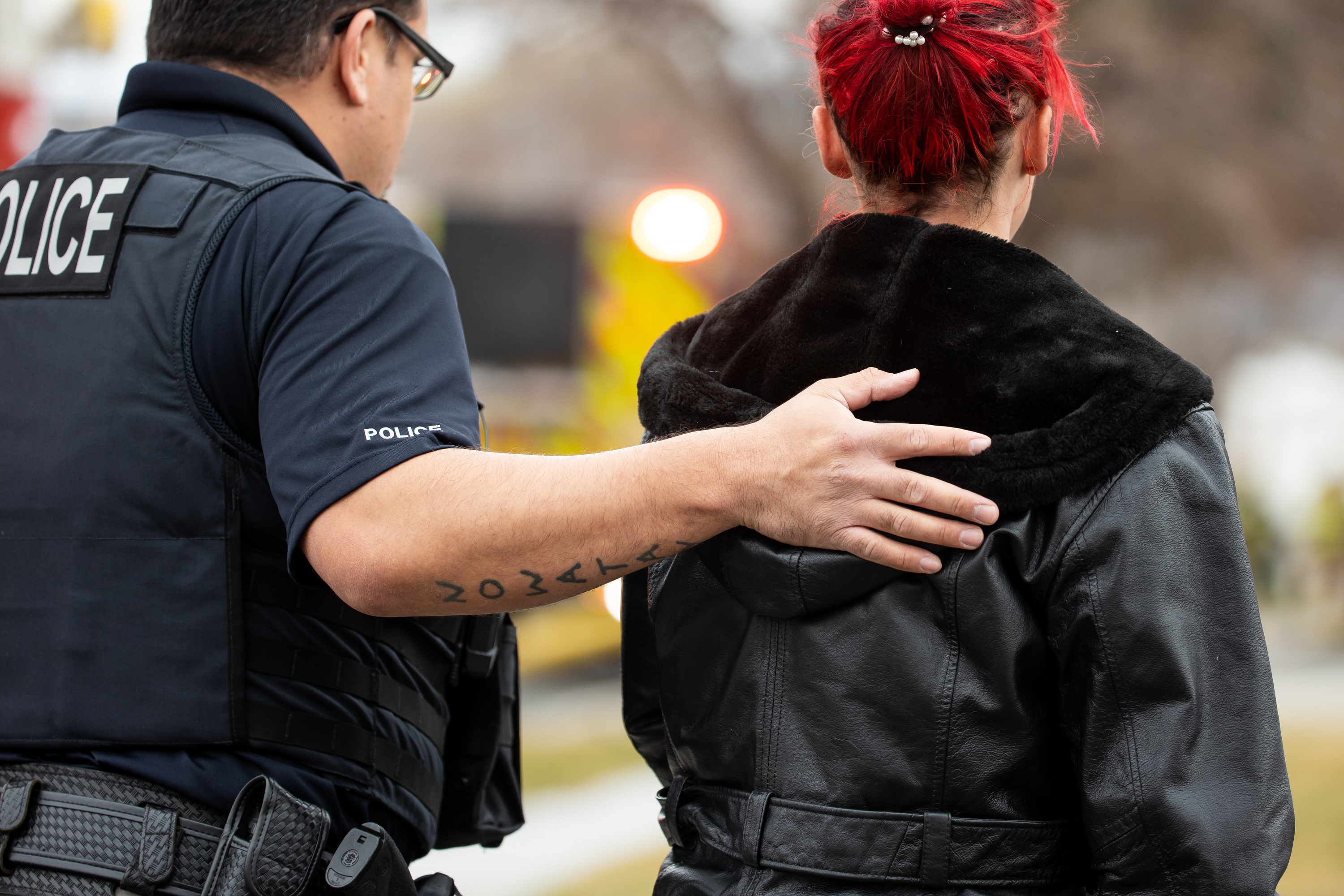 A police officer comforts a woman after a house fire in Taylorsville on Saturday, March 13, 2021. Unified fire officials confirmed one person died in the fire.