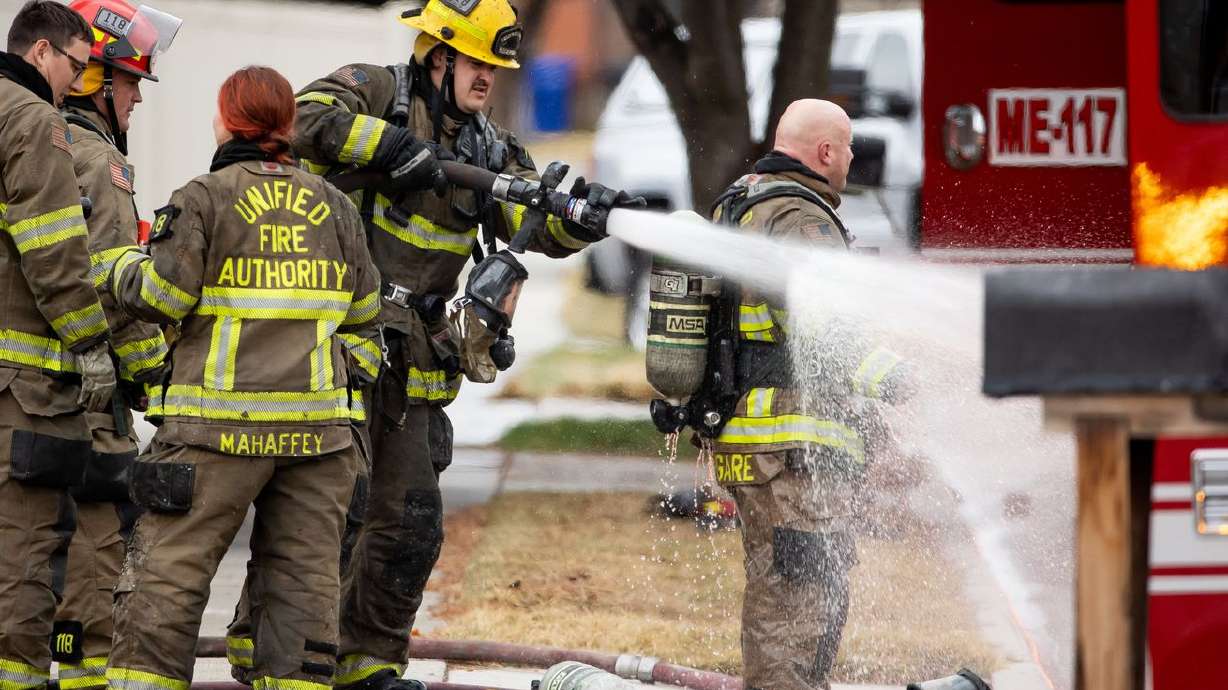 Firefighters clean up after battling a house fire in Taylorsville on Saturday, March 13, 2021. A new Utah bill would require agencies in the state to offer mental health resources for first responders and their families.
