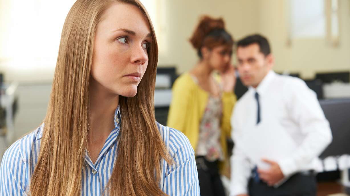 Businesswoman Being Gossiped About By Colleagues In Office