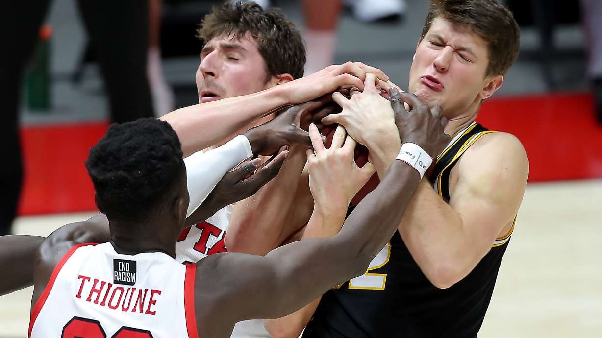 Utah Utes forward Riley Battin (21) and Utah Utes center Lahat Thioune (32) battle Idaho Vandals forward Tanner Christensen (32) for a rebound as the University of Utah and the University of Idaho play a basketball game at the Huntsman Center in Salt Lake City on Friday, Dec. 18, 2020.