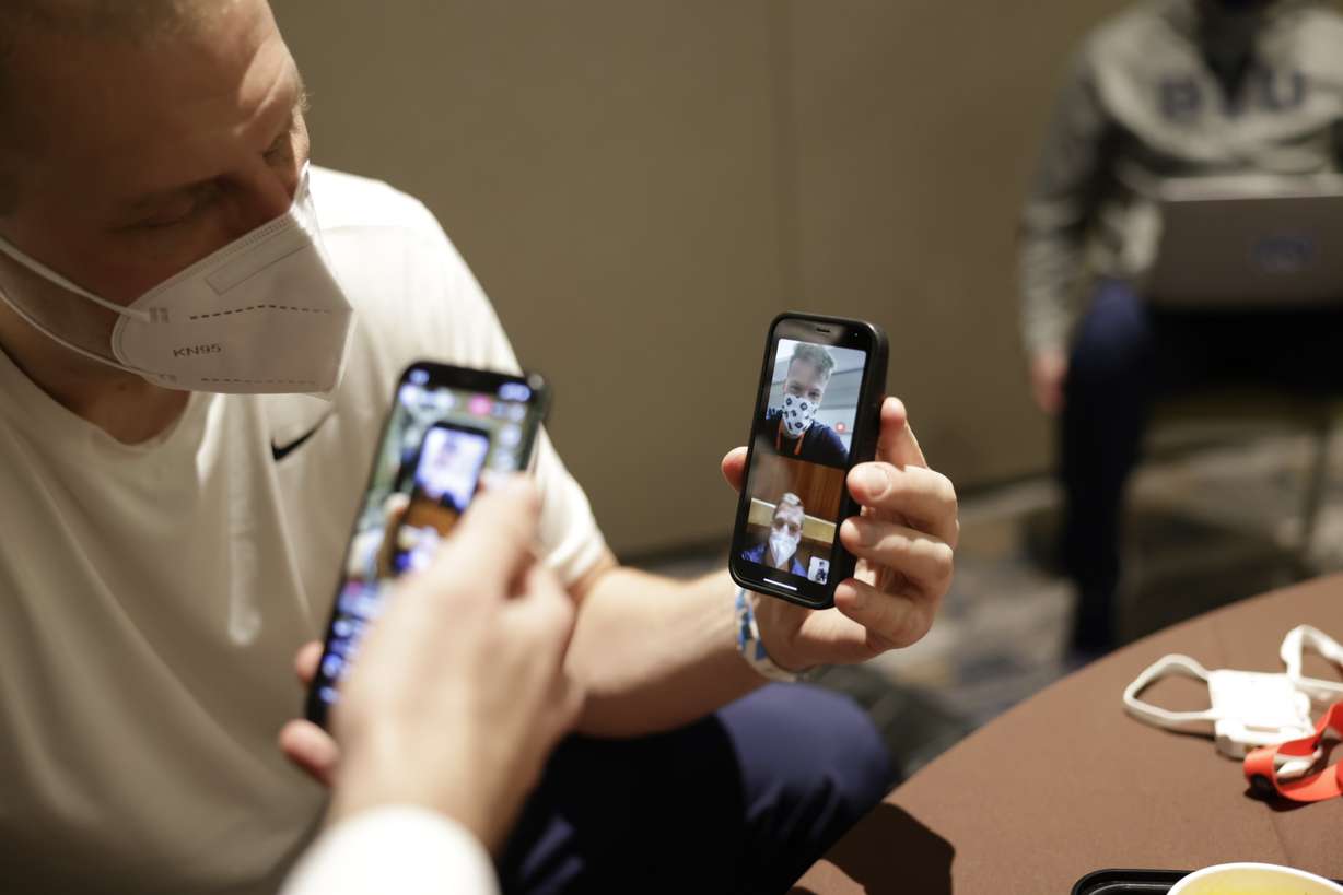 BYU coach Mark Pope takes his turn on a FaceTime with Jesse Wade while the BYU guard was stuck in an elevator at the team hotel, Wednesday, March 18, 2021.