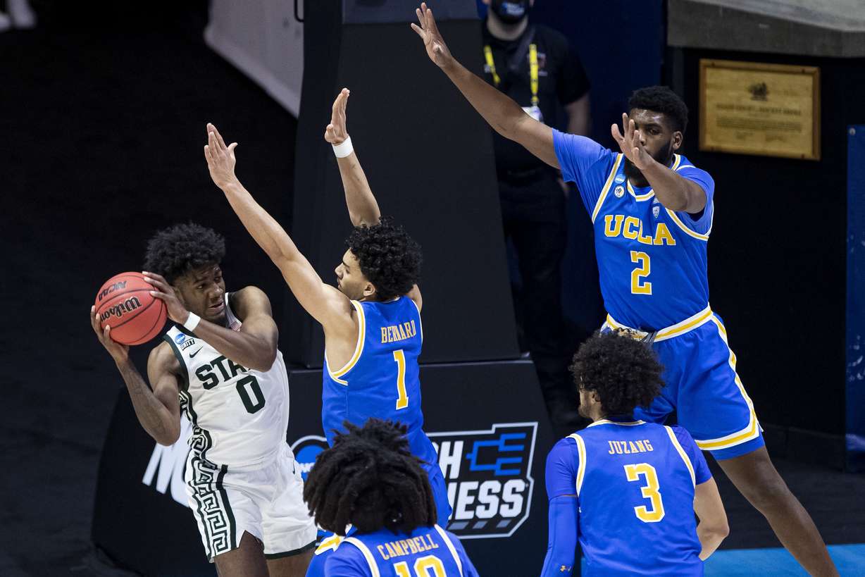 Michigan State's Aaron Henry (0) is defended by UCLA's Jules Bernard (1), Tyger Campbell (10), Johnny Juzang (3) and Cody Riley (2) during the second half of a First Four game in the NCAA men's college basketball tournament, early Friday, March 19, 2021, at Mackey Arena in West Lafayette, Ind. UCLA won 86-80.