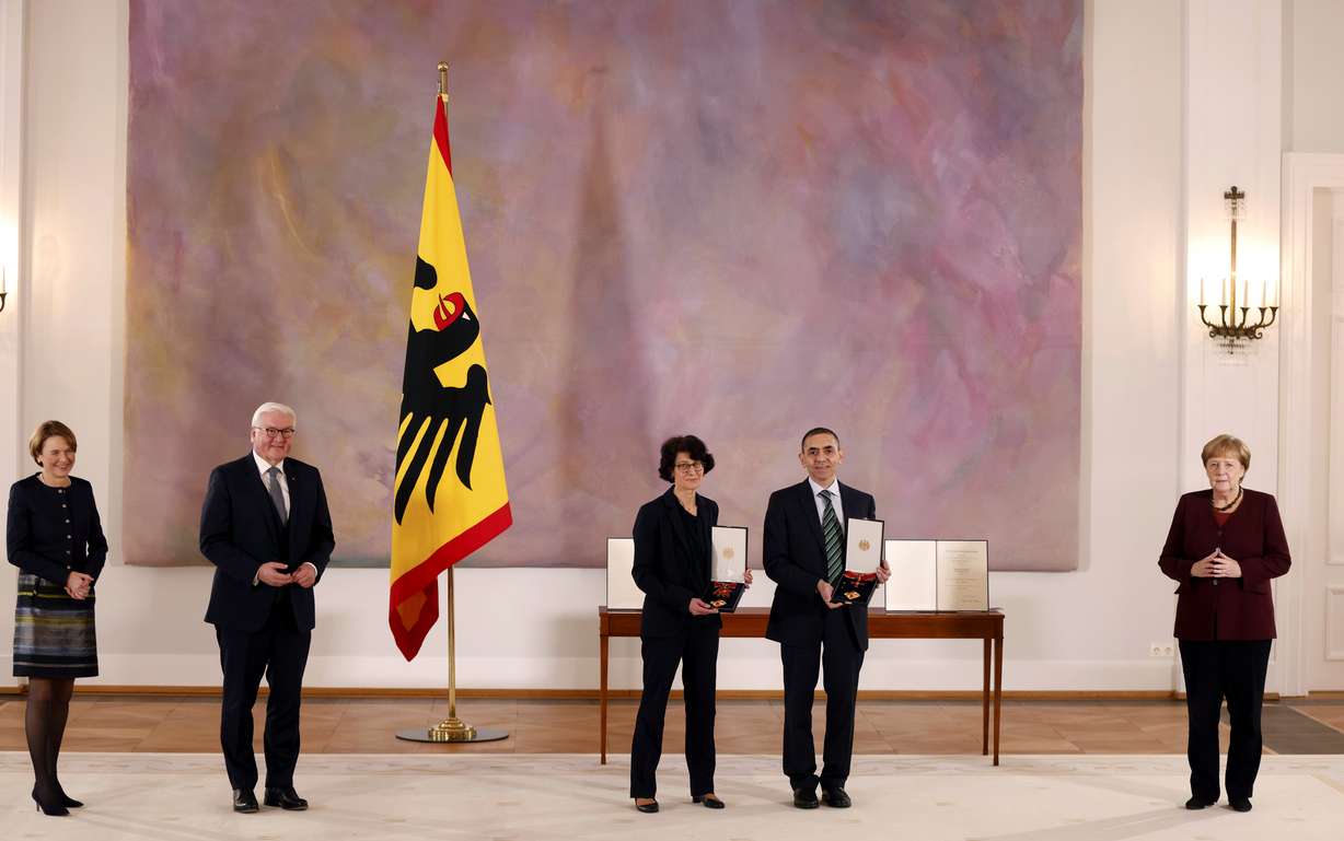 Ozlem Tureci, tgird left, and her husband Ugur Sahin, 2nd right, both scientists and founders of BioNTech, pose with their orders after they were awarded the Federal Cross of Merit (Bundesverdienstkreuz) by German President Frank-Walter Steinmeier, 2nd left, on March 19, 2021 at the presidential Bellevue Palace in Berlin, Germany, Friday, March 19, 2021. At right is German Chancellor Angela Merkel, at left is the wife of the German President Elke Buedenbender.