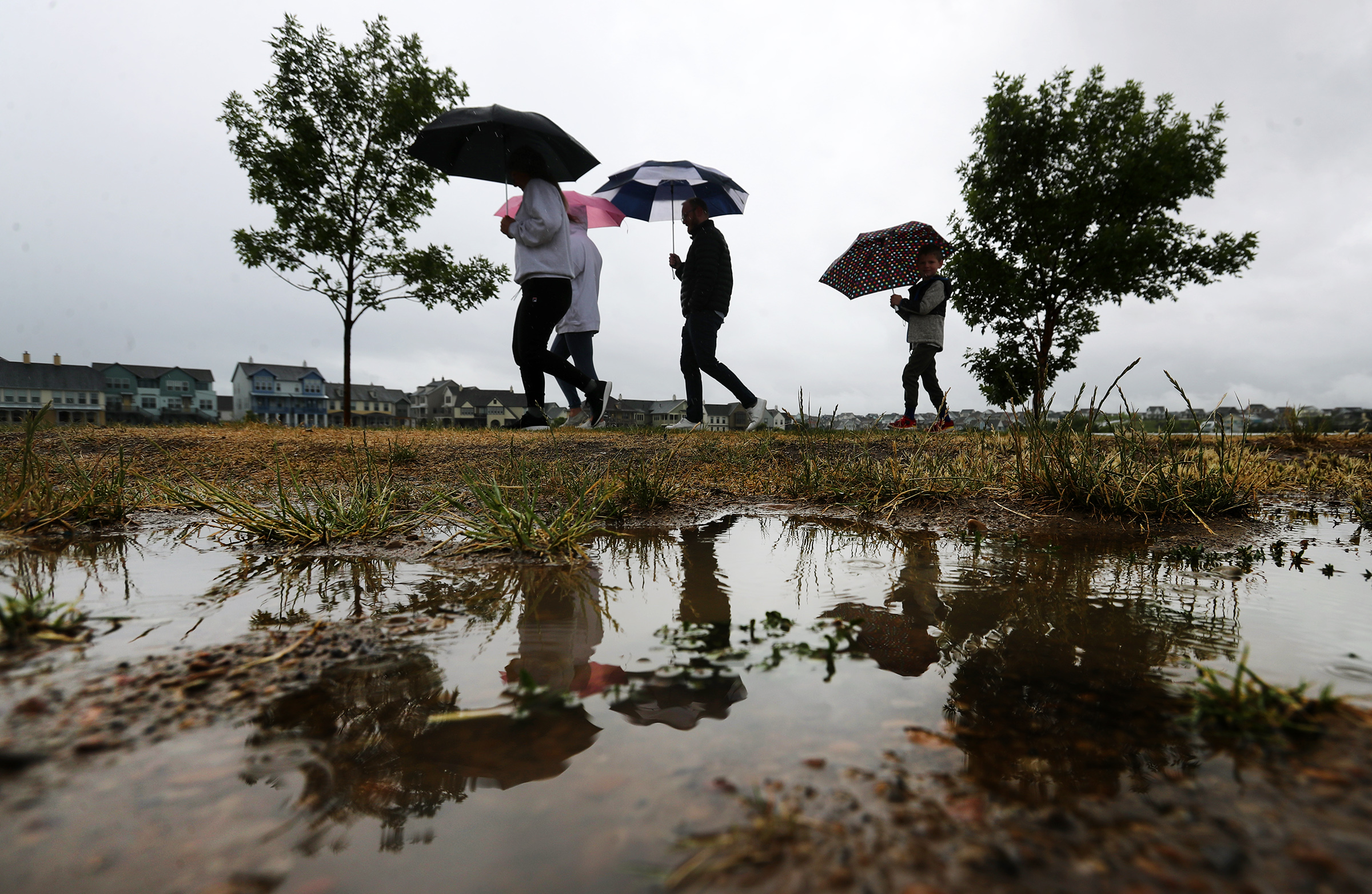 The Warren family takes a walk in the rain around Oquirrh Lake in the Daybreak community on June 7, 2020. The weather forecast calls for more than 1 inch of rain across the Wasatch Front between Tuesday and Saturday.