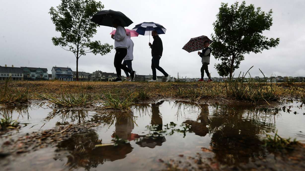 The Warren family takes a walk in the rain around Oquirrh Lake in the Daybreak community on Sunday, June 7, 2020.