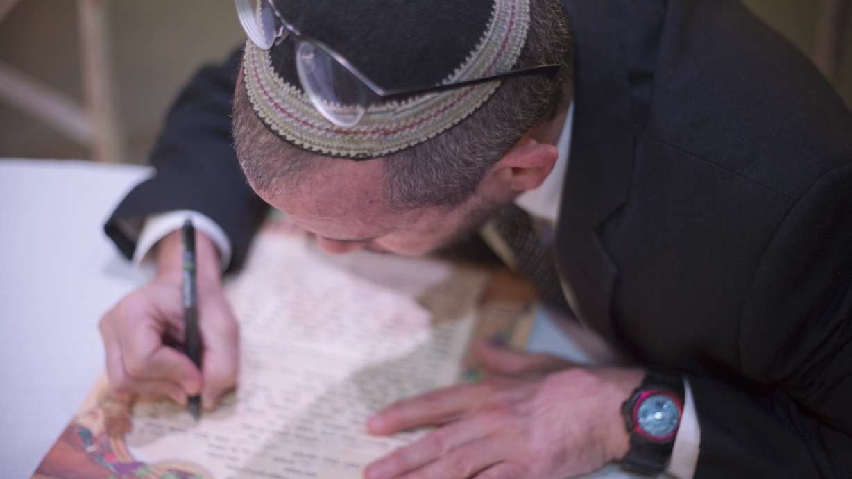 In this Thursday, Dec. 14, 2017 photo, Rabbi Chuck Davidson signs a" Ktuba," a Jewish wedding contract during a wedding in Ein Hemed. A growing number of Israeli couples are defying the country’s Chief Rabbinate and marrying in unsanctioned weddings. The couples include people who have difficulty proving their Jewishness to the strict rabbinic authorities, but many are simply fed up with the establishment’s monopoly over an intimate and emotional custom. (AP Photo/Ariel Schalit)