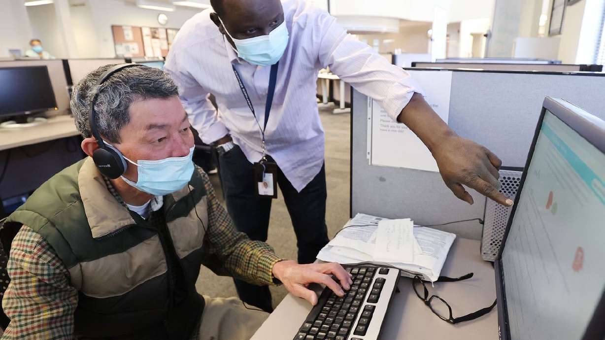 Martin BuBa, an employment counselor at the Utah
Department of Workforce Services’ South County Employment Center in
Taylorsville, right, helps Hsi Cheng look for a job on Friday,
March 19, 2021.
