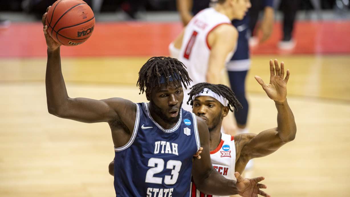 Utah State center Neemias Queta (23) protects the ball during the first half of a first round game against Texas Tech in the NCAA men's college basketball tournament, Friday, March 19, 2021, at Assembly Hall in Bloomington, Ind.