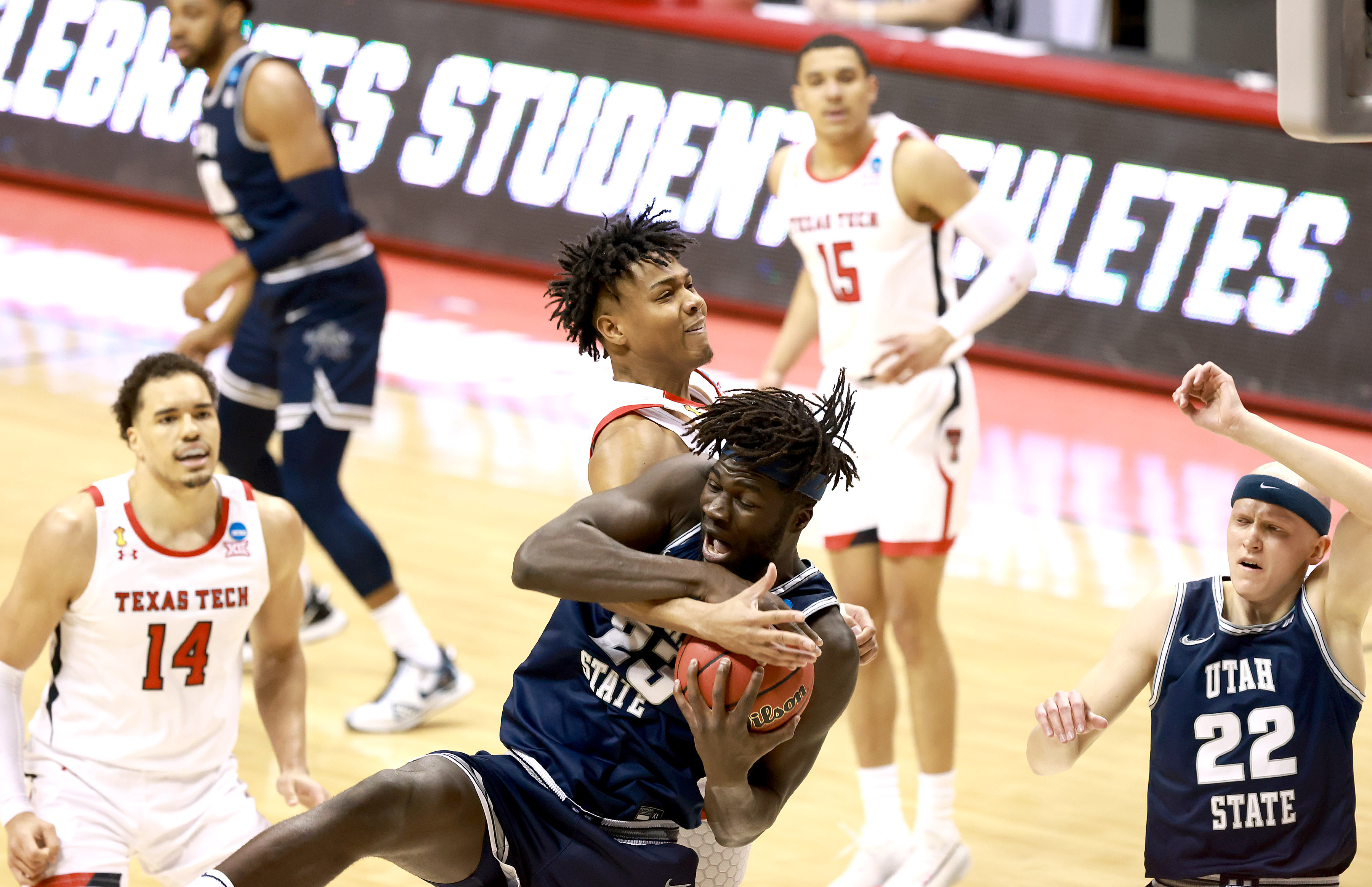 Terrence Shannon Jr. of the Texas Tech Red Raiders ties up with Neemias Queta of the Utah State Aggies as they battle for a rebound in the first round of the 2021 NCAA Division I Men's Basketball Tournament held at Simon Skjodt Assembly Hall on March 19, 2021, in Bloomington, Indiana.
