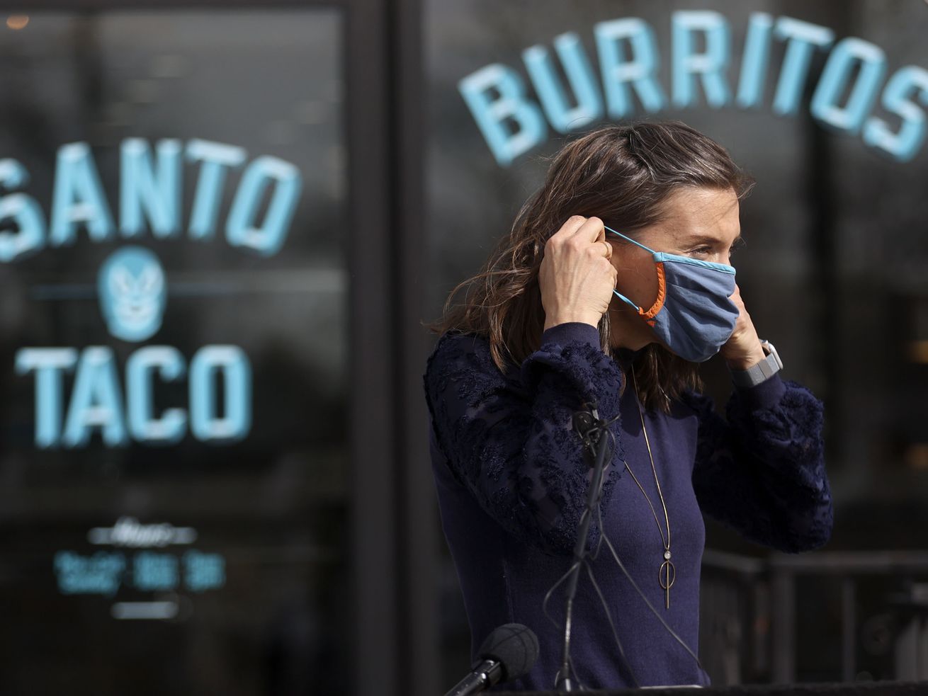 Salt Lake City Mayor Erin Mendenhall puts her mask on
after asking Salt Lake City businesses to continue asking patrons
and staff to wear masks after the state mask mandate is lifted
April 10 during a press conference outside of Santo Taco in Salt
Lake City on Friday, March 19, 2021.
