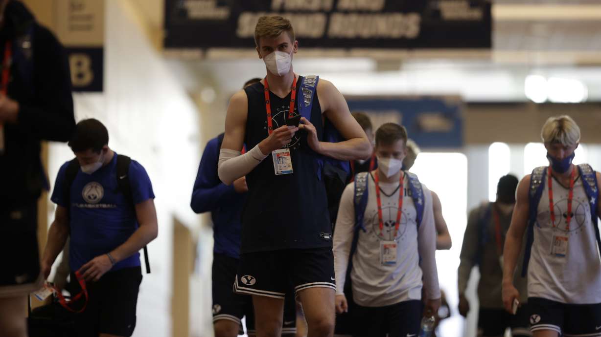 Matt Haarms motions to the camera as he, Jesse Wade and Hunter Erickson headed to practice with BYU basketball, Friday, March 19, 2021 at the NCAA Tournament in Indianapolis.