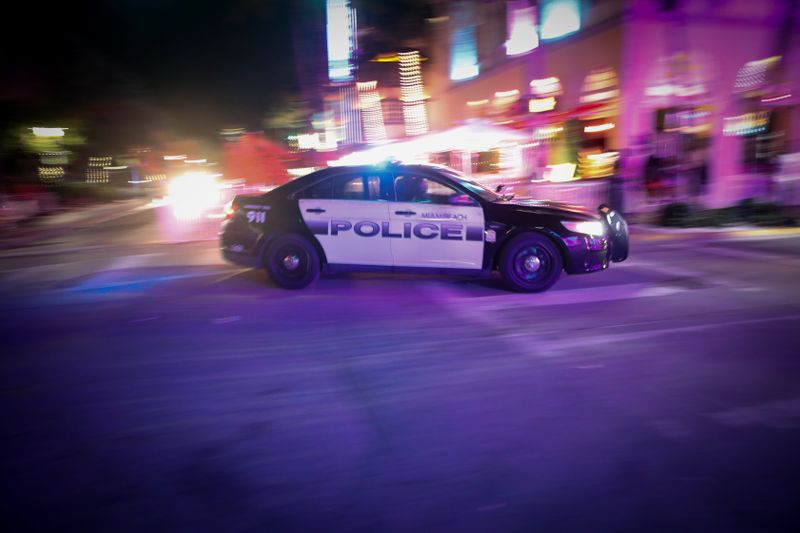 A police vehicle chases revelers to enforce an 8pm curfew imposed by local authorities on spring break festivities, amid the coronavirus disease (COVID-19) pandemic, in Miami Beach, Florida, U.S., March 20, 2021. REUTERS/Marco Bello