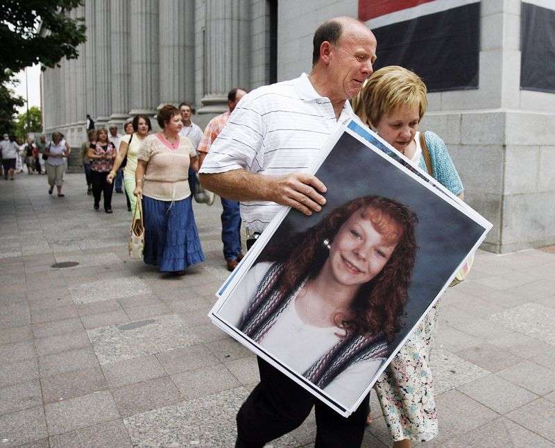 Richard and Tamara Davis show emotion as they leave court carrying a photo of their daughter Kiplyn Davis on July 19, 2006. Timmy Olsen, who was convicted of manslaughter, was ordered by the Utah Board of Pardons and Parole to serve his full 15-year sentence, which expires on Feb. 10, 2026.