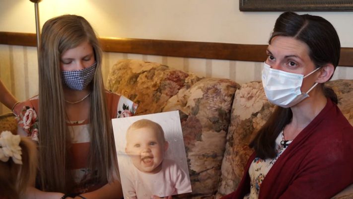 Angela Jacobs sits beside her oldest child as they look at a photo of the teenager when she was a baby.