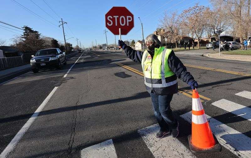 Crossing guard Irene Adolf moves a cone in a school
zone in West Valley City on Wednesday, March 24, 2021, as West
Valley police conduct a crosswalk safety operation.
