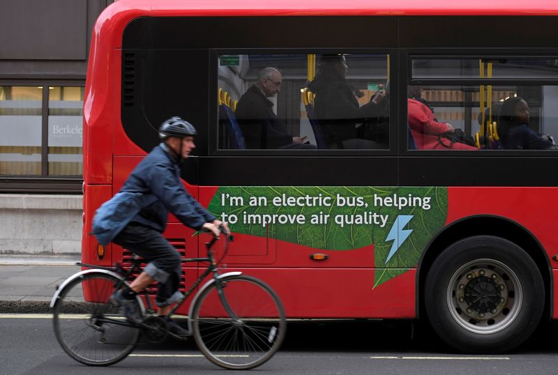 FILE PHOTO: A cyclist rides past an electric public bus on the day that Mayor of London Sadiq Khan outlined plans to place a levy on the most polluting vehicles in London, Britain, April 4, 2017.  REUTERS/Toby Melville/File Photo