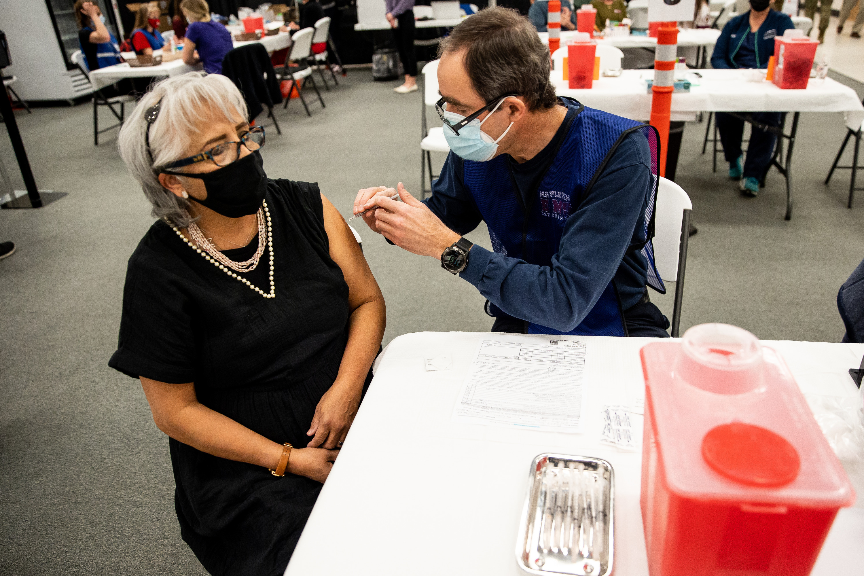 Patty E. Davis receives a dose of the Pfizer-BioNTech COVID-19 vaccine from Ben Christensen, an advanced EMT volunteering from the Mapleton fire department, at a vaccination site run by the Utah County Health Department in Spanish Fork on Thursday, March 25, 2021.