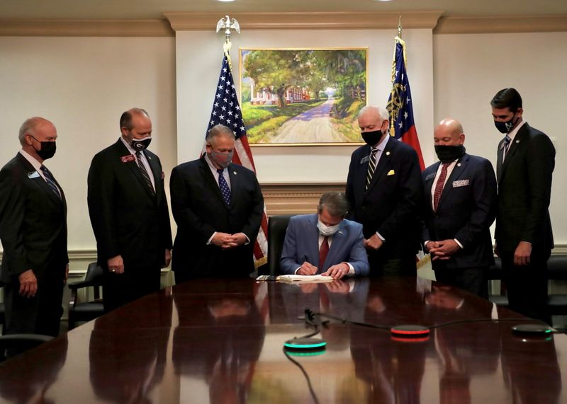 FILE PHOTO: Republican Governor Brian Kemp signs the law S.B. 202, a restrictive voting law that activists have said aimed to curtail the influence of Black voters who were instrumental in state elections that helped Democrats win the White House and narrow control of the U.S. Senate, in this handout photo posted to Kemp's Twitter feed on March 25, 2021. Governor Brian Kemp's Twitter feed/Handout via REUTERS