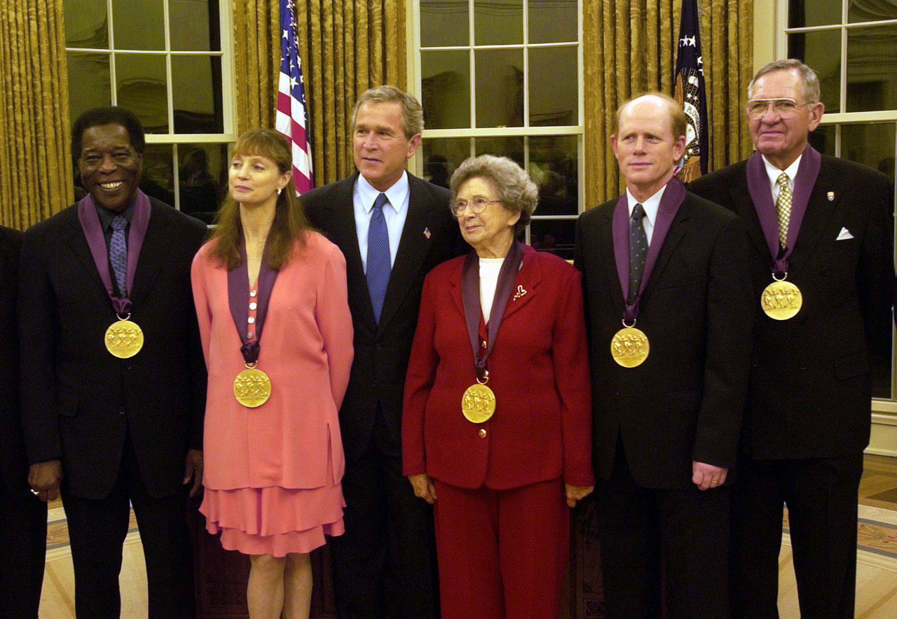 President George W. Bush poses with National Medal of the Arts recipients during a ceremony in the Oval Office at the White House in Washington, Wednesday, Nov. 12, 2003. Several of the 10 recipients pictured from left to right: Buddy Guy, blues musician; Suzanne Farrell, dancer, artistic director and arts educator; President Bush; Beverly Cleary, children's book author; Ron Howard, actor and director; and Mac Christensen, then-president of the Mormon Tabernacle Choir.