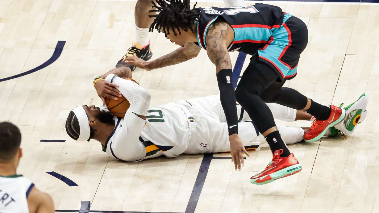 Utah Jazz guard Mike Conley (10) pulls in a loose ball under Memphis Grizzlies guard Ja Morant (12) during the final seconds of the game at Vivint Smart Home Arena in Salt Lake City on Friday, March 26, 2021.