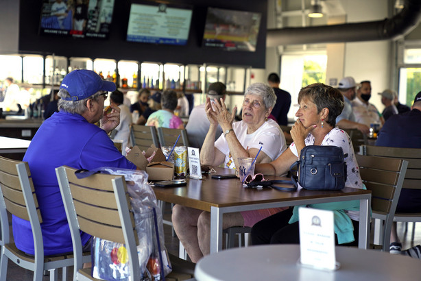 Baseball fans gather in the Bullpen Club at George M. Steinbrenner Field before a spring training exhibition baseball game between the New York Yankees and the Toronto Blue Jays in Tampa, Fla., Wednesday, March 24, 2021. Spring has arrived, and many older adults who have been vaccinated are emerging from hibernation imposed by the coronavirus pandemic.