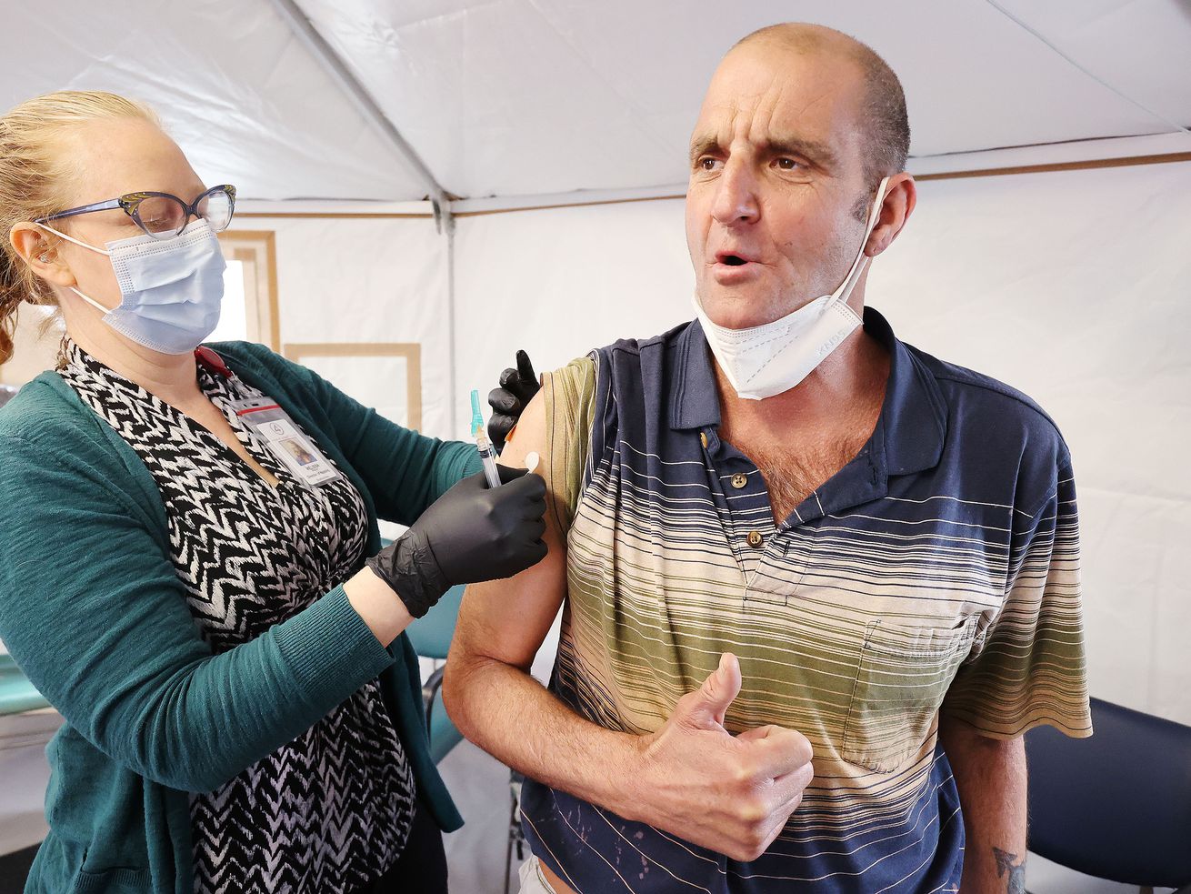 Melissa Mason gives Kenny Collins, who is homeless, a
COVID-19 vaccination at the Fourth Street Clinic in Salt Lake City
on Tuesday, March 23, 2021.