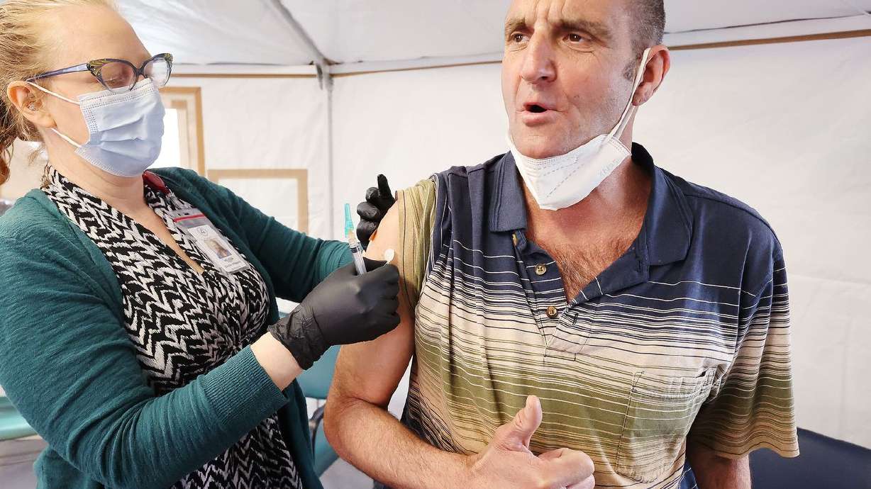 Melissa Mason gives Kenny Collins, who is homeless, a
COVID-19 vaccination at the Fourth Street Clinic in Salt Lake City
on Tuesday, March 23, 2021.