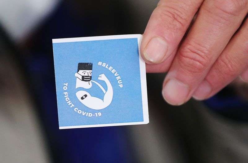 A man experiencing homelessness holds a sticker after receiving a COVID-19 vaccination at the Fourth Street Clinic in Salt Lake City on Tuesday, March 23, 2021.