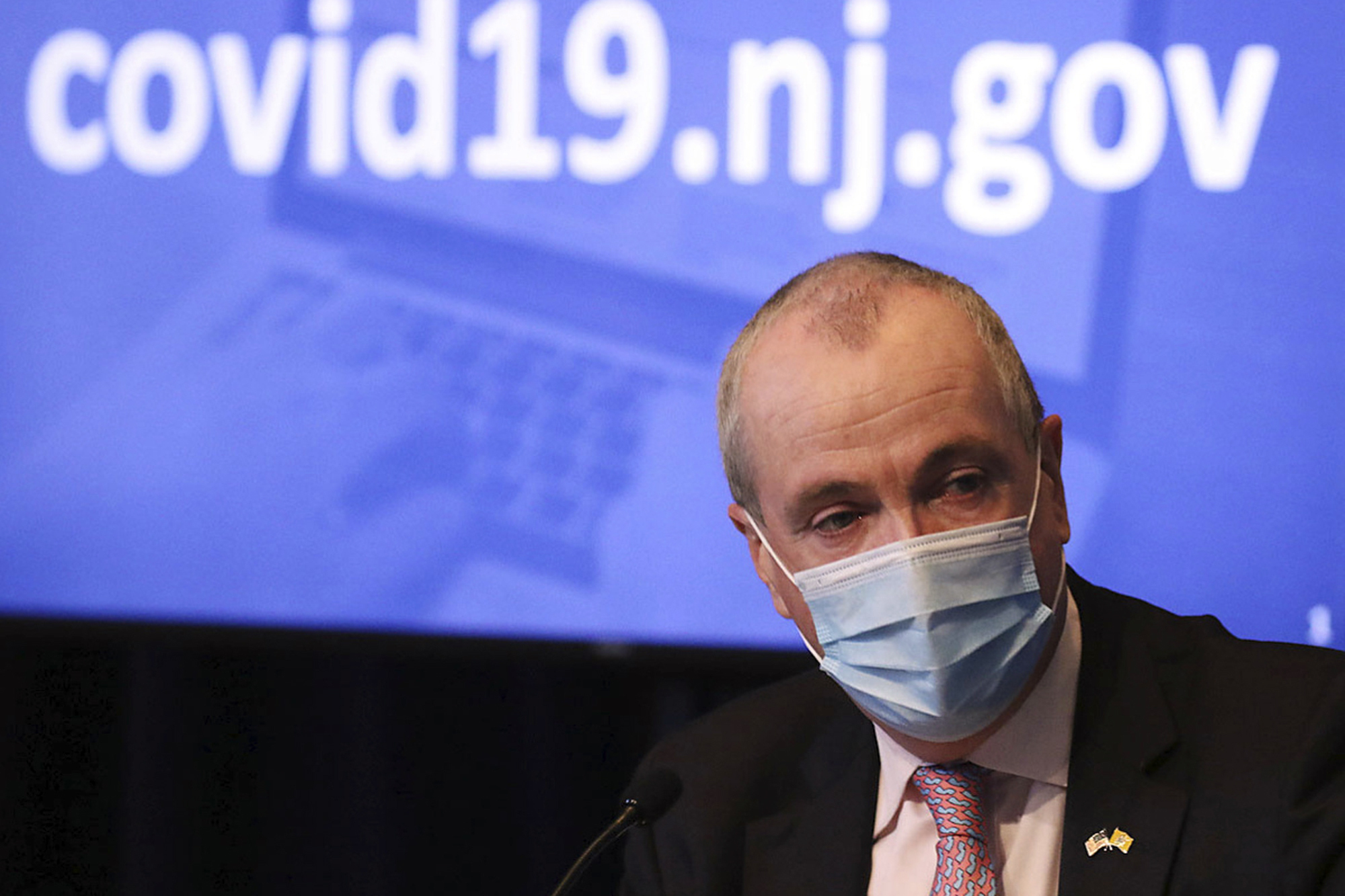FILE - In this May 19, 2020, file photo, New Jersey Gov. Phil Murphy wears a mask during his daily coronavirus news conference at the War Memorial in Trenton, N.J. A year after becoming a global epicenter of the coronavirus pandemic, New York and New Jersey are back atop the list of U.S. states with the highest rates of infection. Murphy said in recent days that he is hitting pause on further loosening of the rules because of New Jersey's resurgence.
