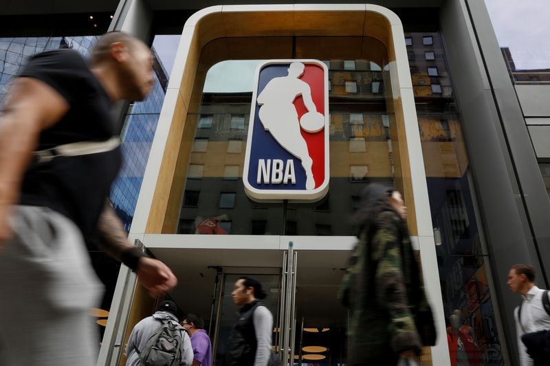 FILE PHOTO: The NBA logo is displayed as people pass by the NBA Store in New York City, U.S., October 7, 2019. REUTERS/Brendan McDermid
