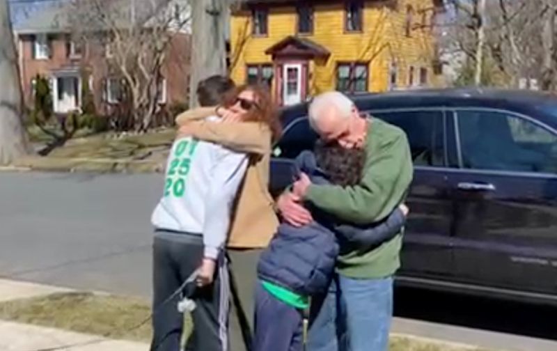 Esther Greenberg, 74, and her husband Bob Greenberg, 76, hug their grandsons Noah Barkin, 14, and Alex Barkin, 11, outside the children’s home in Maplewood, New Jersey, U.S. March 13, 2021, after a long separation forced by coronavirus disease (COVID-19) restrictions, in this frame grab taken from a video. Cheryl Barkin/Handout via REUTERS