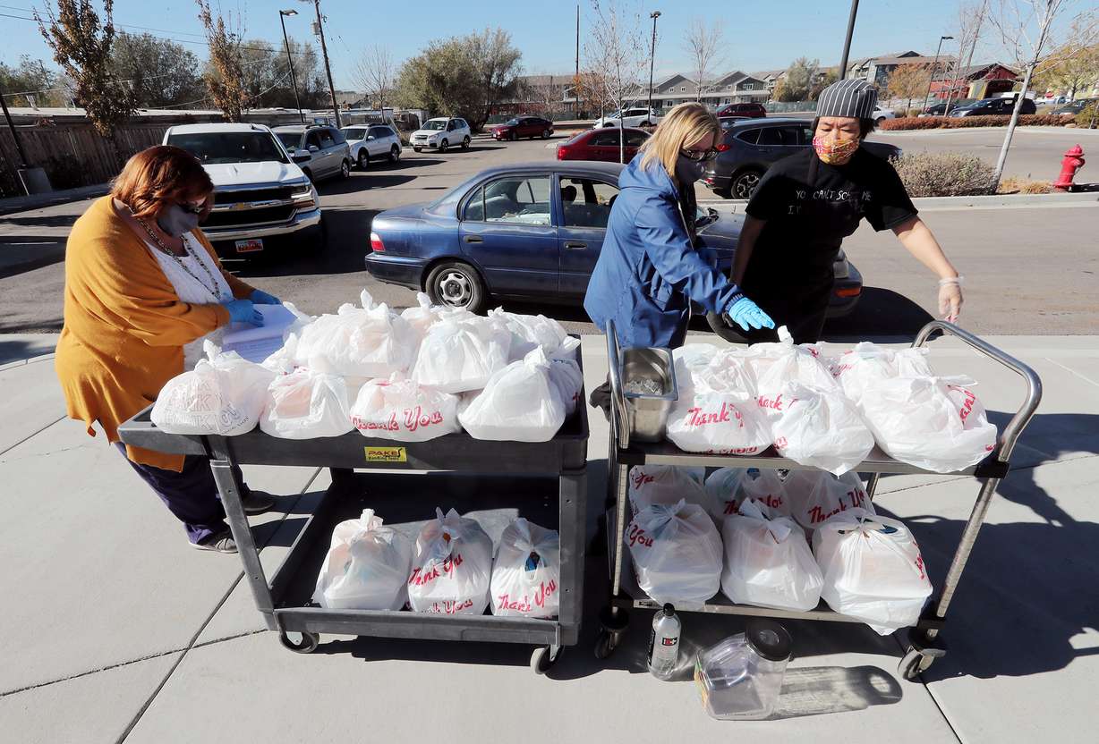 Manager Loriann Warner, program coordinator Kim Rasmussen and food server Mari Orikasa work to pass out food as seniors drive up and receive lunches at the Midvale Senior Center on Monday, Nov. 2, 2020.